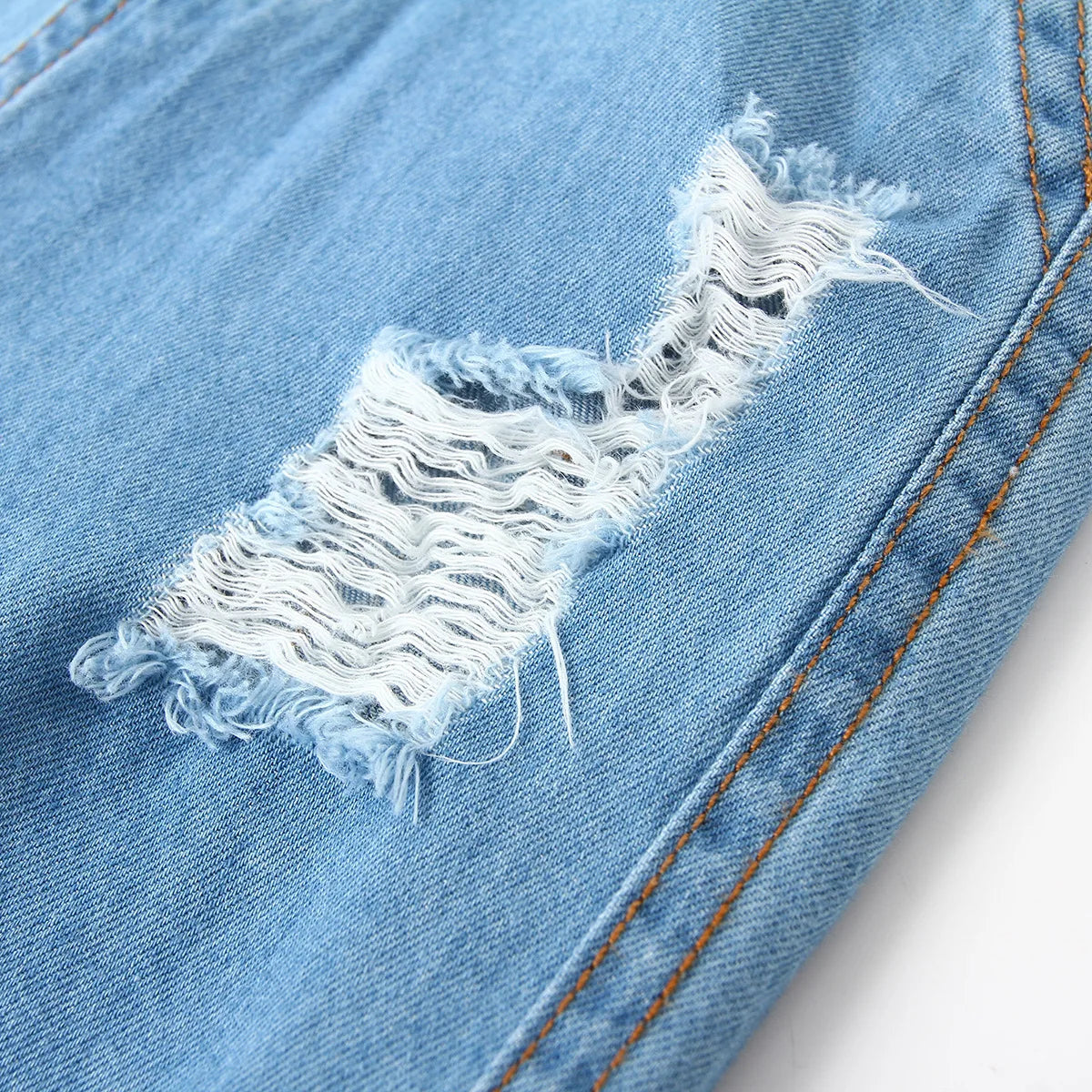 Vaqueros HoneyCherry de moda para niño. Estos pantalones tienen un acabado esmerilado y presentan agujeros rotos a la moda.