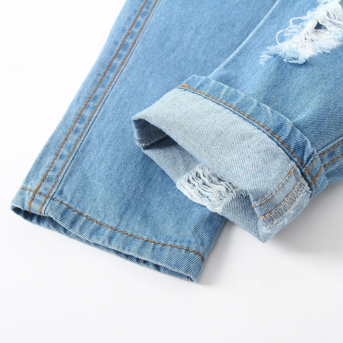 Vaqueros HoneyCherry de moda para niño. Estos pantalones tienen un acabado esmerilado y presentan agujeros rotos a la moda.